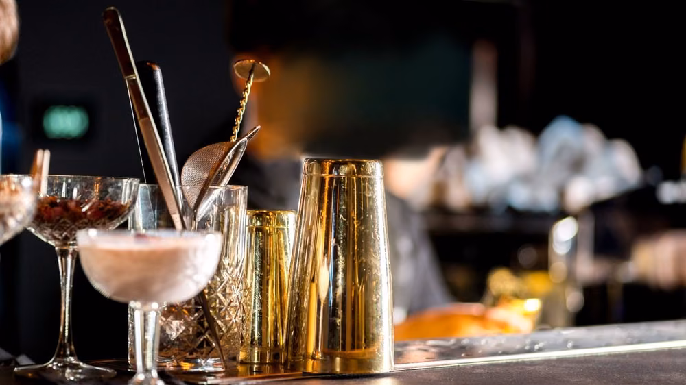Craft cocktails and gold bar tools set up for an evening event