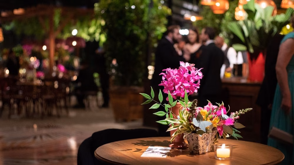 Pink floral centerpiece and candlelight on a cocktail hour table