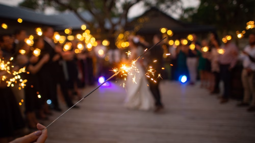 Close-up of a sparkler send-off with the bride blurred in the background