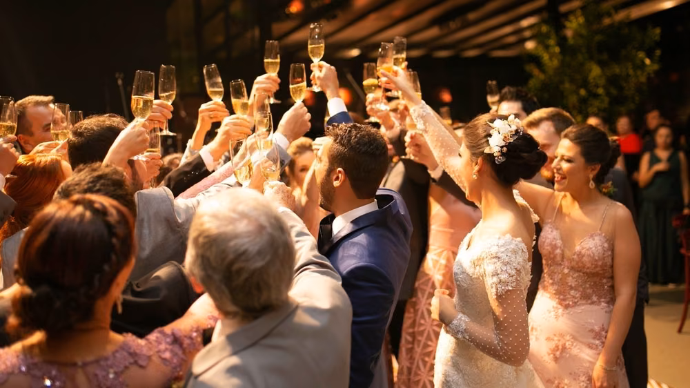 Wedding guests raising champagne glasses in a toast to the newlyweds